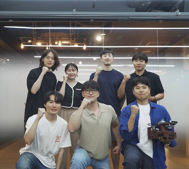 유병호 대표(왼쪽 첫째)와 오민호·이동규 공동 최고기술책임자(앞줄 왼쪽 둘째부터) 등 유로보틱스 직원들이 연구실에서 주먹을 불끈 쥐고 웃고 있다. 이들 직원들은 명현 KAIST 전기및전자공학부 교수 연구실 출신들이다. [사진=유로보틱스]