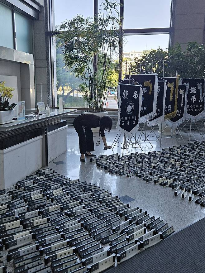 한 금융감독원 직원이 로비에 명패를 내려놓고 있다/사진=김도엽 기자