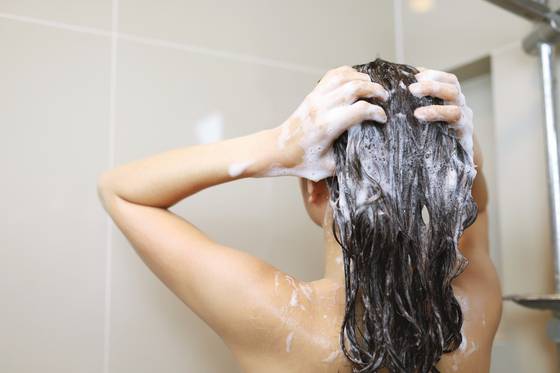 A woman washes her hair with shampoo. [CJ OLIVE YOUNG]