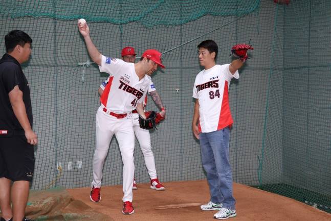 KIA 제임스 네일(왼쪽)이 11일 광주 롯데전을 앞두고 최인후 소방관의 시구를 지도하고 있다. /사진=KIA 타이거즈 제공