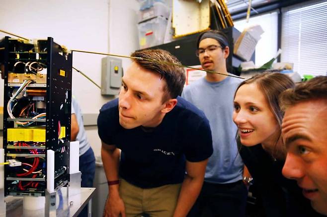 스페이스X 산학협력 프로그램에 참여한 미시간대 연구원들이 소형 위성 장비를 점검하고 있다. / 사진=미시간대