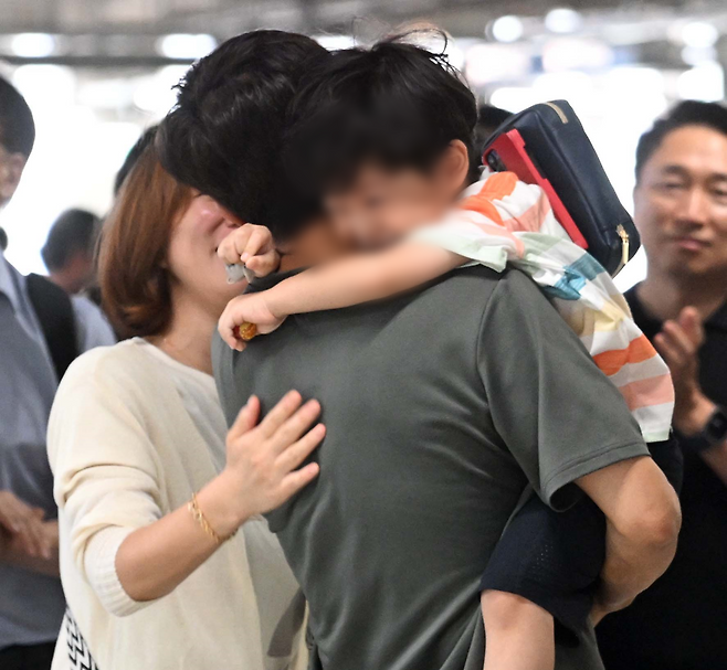 South Korean national who returned home after being detained in the US greets his family at the Incheon International Airport on Friday. (Yonhap)