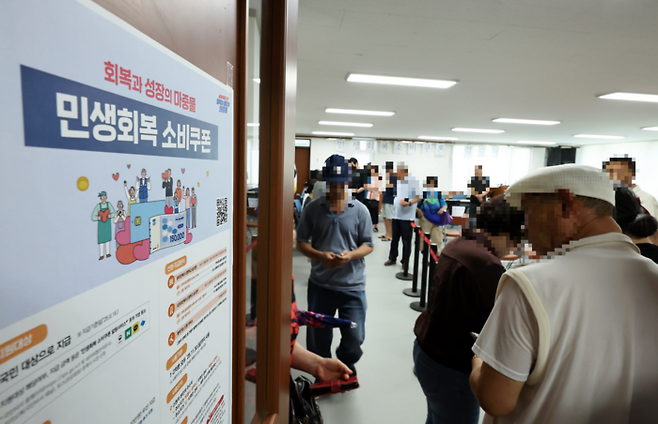 민생회복 소비쿠폰 1차 신청 첫날일 21일 광주 북구 두암3동 행정복지센터에서 시민들이 소비쿠폰을 신청하고 있다. [사진 출처 = 연합뉴스]