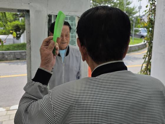 대문에 걸린 거울을 보는 한종상(101). 김서원 기자