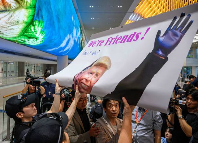 미국 이민당국에 의해 조지아주에 구금됐던 한국인 근로자들이 귀국한 12일 인천국제공항 제2여객터미널 입국장에서 이제석 이제석광고연구소 대표가 트럼프 미국 대통령의 모습이 담긴 플래카드 퍼포먼스를 벌이고 있다. 연합뉴스