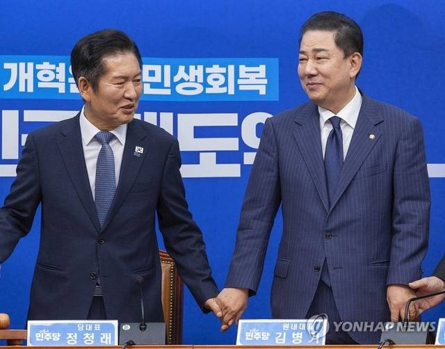 정청래 더불어민주당 대표와 김병기 원내대표를 비롯한 최고위원들이 15일 국회에서 열린 최고위원회의에 입장해 서로 손을 잡고 있다. [연합뉴스]