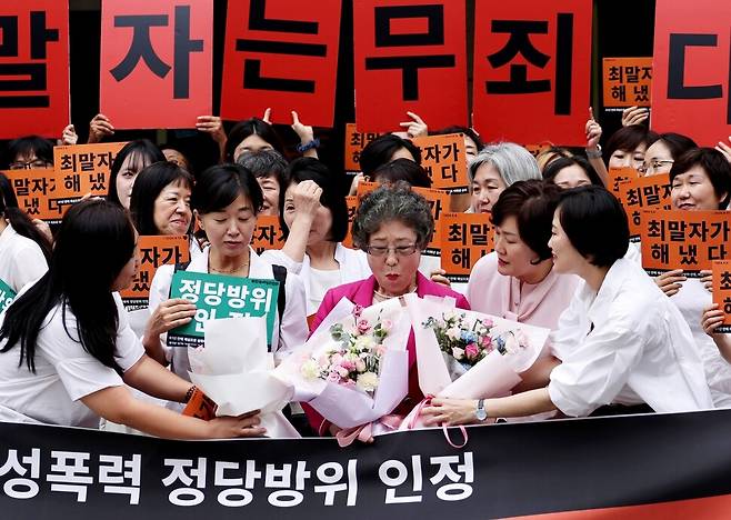 1964년 자신을 성폭행하려던 남성의 혀를 깨물었다는 이유로 중상해 혐의로 기소돼 유죄 선고를 받았던 최말자씨(가운데)가 재심에서 최종 무죄 판단을 받은 10일 오후 부산 연제구 부산지법에서 참석자들로부터 꽃다발을 받고 있다. 부산=이종근 선임기자 root2@hani.co.kr