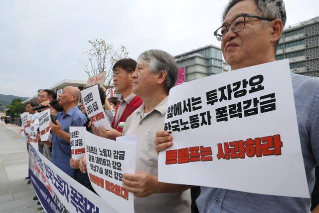 9일 서울 종로구 주한 미국대사관 인근에서 열린 ‘굴욕적 대미 투자 강요 및 한국 노동자 폭력적 인권 유린 미국 트럼프 정부 규탄’ 시민사회단체 기자회견의 참석자들이 손 팻말을 들고 서 있다. 뉴스1