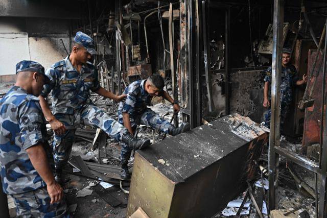 14일 네팔 카트만두 국회의사당에서 보안요원들이 피해 상황을 점검하고 있다. 카트만=AFP 연합뉴스