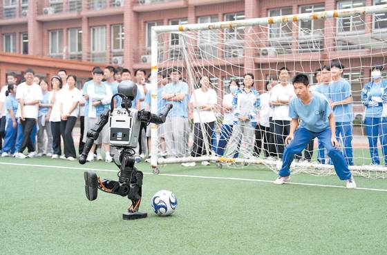 베이징 르탄중학교 운동장에서 학생들이 휴머노이드가 차는 공을 막고 있다. 중국 베이징시는 9월 신학년을 맞아 1400여개 초중고에 최소 8교시의 인공지능 과목을 개설했다. 북경일보 캡처