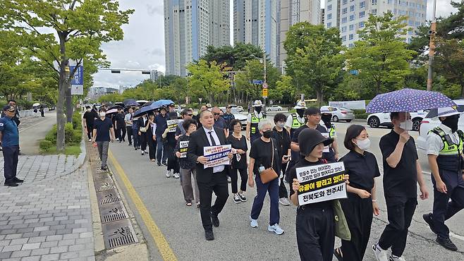 전주 자임추모공원 유족들이 지난 1일 전북도청 앞에서 전북도와 전주시를 향해 "유골의 안전과 추모권을 보장해 달라"고 요구하며 거리를 행진하고 있다. 사진 자임유가족협의회