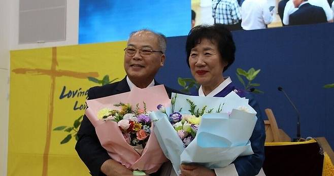 조형국 장로가 부인과 함께 꽃다발을 들고 기념 촬영을 하고 있다.