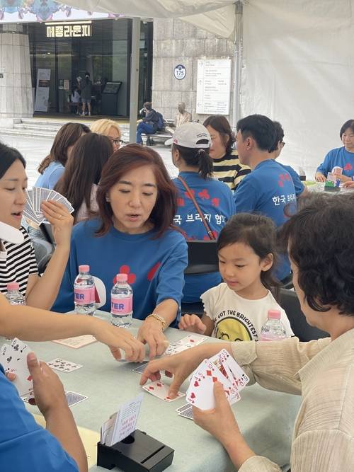 한국브리지협회는 13일과 14일 서울 광화문광장에서 열린 ‘2025 서울 익스트림 스포츠 페스티벌’에 참여했다고 14일 밝혔다. 이번 행사는 서울시와 서울시체육회가 공동 주최했으며 한국브리지협회는 회원종목단체 자격으로 홍보 부스를 운영했다. 이날 행사장에서 김혜영 한국브리지협회 회장이 홍보부스를 찾은 시민들에게 직접 브리지에 대해 설명해주고 있다. <한국브리지협회>