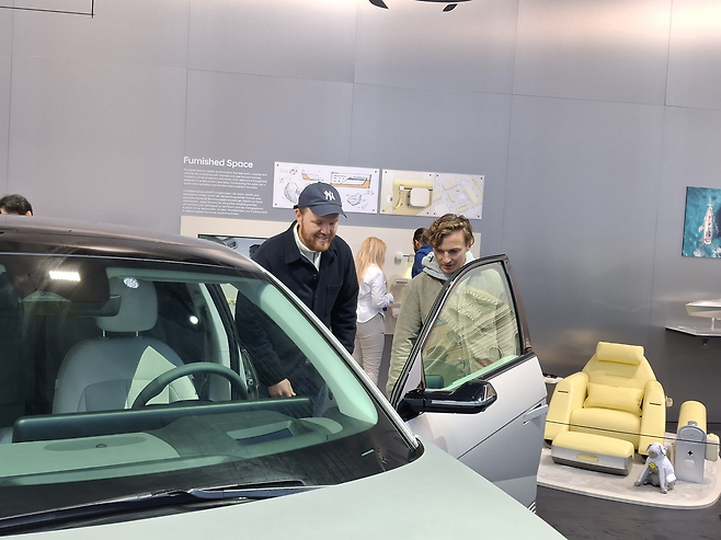 현대차 부스를 방문한 젊은 남성들이 아이오닉 5의 운전석 도어를 살피고 있다 [뮌헨=김성우 기자]