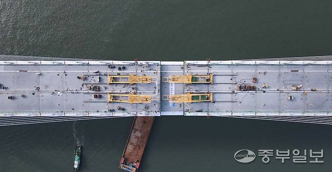 지난 12일 인천시 중구 영종하늘도시와 서구 청라국제도시와를 잇는 제3연륙교 사장교 구간에서 대형 크레인이 마지막 상판을 들어 올려 주탑과 연결하는 작업이 진행되고 있다. 이날 최종 연결은 수개월간 이어진 정밀 시공 끝에 이뤄진 것으로, 제3연륙교가 본격적인 완성 단계에 접어들었음을 알리는 상징적인 순간이 됐다.정선식기자