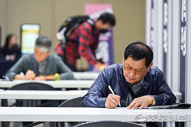 고양시 일산서구 킨텍스 제1전시장에서 열린 '경기도 5070 일자리박람회'를 찾은 시민들이 신중하게 이력서를 작성하고 있다. 임채운기자