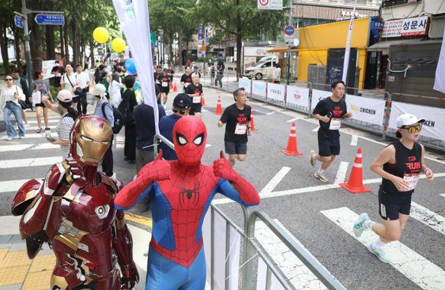 14일 서울광장에서 열린 ‘마블런 서울 2025’ 행사에서 참가자들이 서울광장을 출발해 마블 캐릭터의 응원을 받으며 도심을 달리고 있다. 디즈니코리아 제공