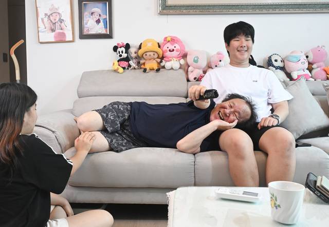 맞벌이 아들 부부를 대신해 어린 손주를 8년 간 돌본 박연규씨가 이젠 훌쩍 자라 든든해진 손자 박이준군, 손녀 박하윤양과 함께 자택 거실에서 텔레비전을 보며 환하게 웃고 있다. 조주현기자