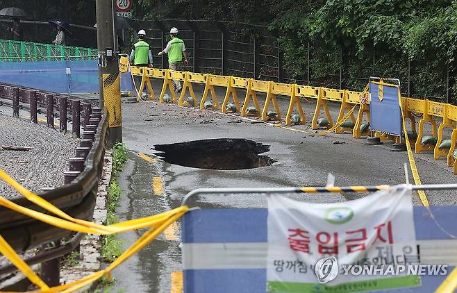 집중호우로 도선사 진입로 땅 꺼짐 발생 (서울=연합뉴스) 서대연 기자 = 서울 곳곳에 호우주의보가 내린 13일 집중호우로 인한 땅 꺼짐 현상이 발생한 서울 강북구 도선사 진입로에 시민들의 접근을 막는 펜스가 설치돼 있다. 2025.8.13 dwise@yna.co.kr