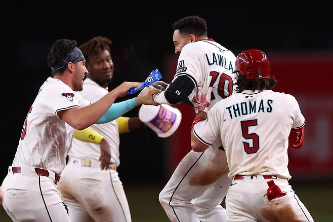 애리조나 조던 롤러가 9회말 끝내기 안타를 터뜨리자 알렉 토마스 등 동료들이 달려들어 기뻐하고 있다. AFP연합뉴스