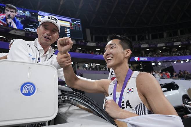 [도쿄=AP/뉴시스] 우상혁이 16일 일본 도쿄 국립경기장에서 열린 2025 도쿄 세계육상선수권대회 남자 높이뛰기 결선에서 2ｍ34로 은메달을 획득한 뒤 메달을 목에 걸고 기뻐하고 있다. 2025.09.16.