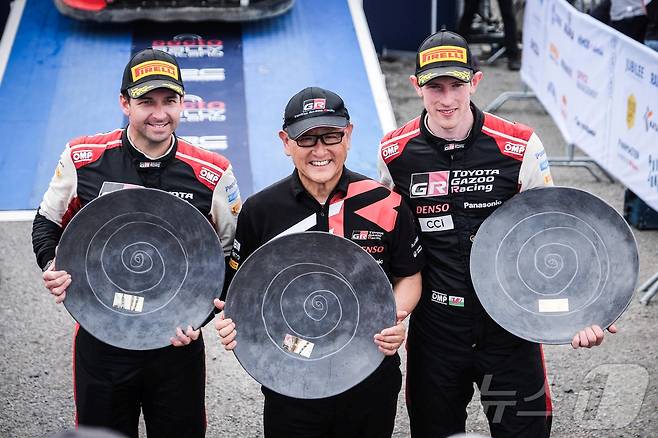 도요타 아키오 도요타그룹 회장(가운데)이 토요타 가주 레이싱팀 선수인 엘핀 에반스(오른쪽) 스콧 마틴(왼쪽)과 함께 2023년 8월 핀란드 위배스퀼래에서 열린 월드 랠리 챔피언십(WRC) 핀란드 랠리 우승을 축하하는 모습. 2023.08.07. ⓒ 로이터=뉴스1 ⓒ News1 김성식 기자
