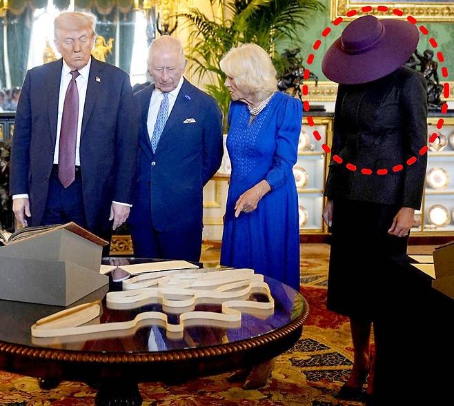 17일(현지 시간) 영국 윈저성에서 도널드 트럼프 미국 대통령(왼쪽 두번째)와 영부인 멜라니아 여사(오른쪽)이 찰스 3세 국왕(왼쪽 세번째)와 카밀라 왕비(오른쪽 두번째)의 전시 물품 설명을 듣고 있다. 챙이 넓은 모자를 쓴 멜라니아 여사는 얼굴이 보이지 않는다. 버크셔=AP 뉴시스