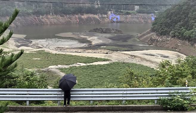 폭우가 쏟아진 지난 17일 한 강릉시민이 강원 강릉지역 생활용수의 87%를 공급하는 상수원 오봉저수지를 바라보고 있다. 연합뉴스