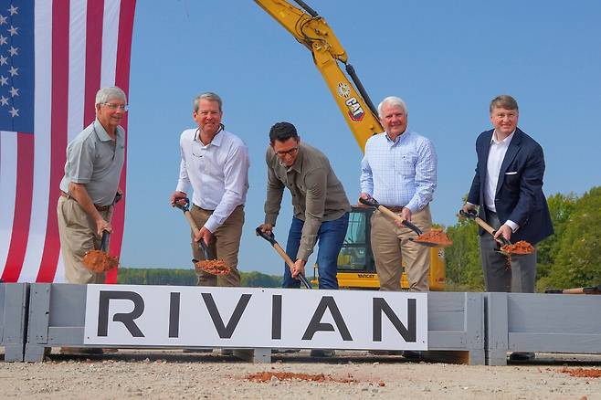 브라이언 켐프 조지아주 주지사(왼쪽 두 번째)와 리비안 자동차의 창립자이자 최고경영자 RJ 스캐린지(가운데), 팻 윌슨 조지아주 경제개발부 장관(오른쪽 끝)이 지난 16일(현지시각) 조지아주 리비안 전기자동차 공장 착공식에서 함께 삽을 뜨고 있다. AP 연합뉴스
