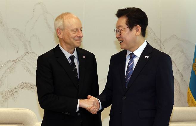 이재명 대통령이 18일 서울 용산 대통령실에서 마이클 샌델 하버드대학교 교수와 악수하고 있다. 연합뉴스