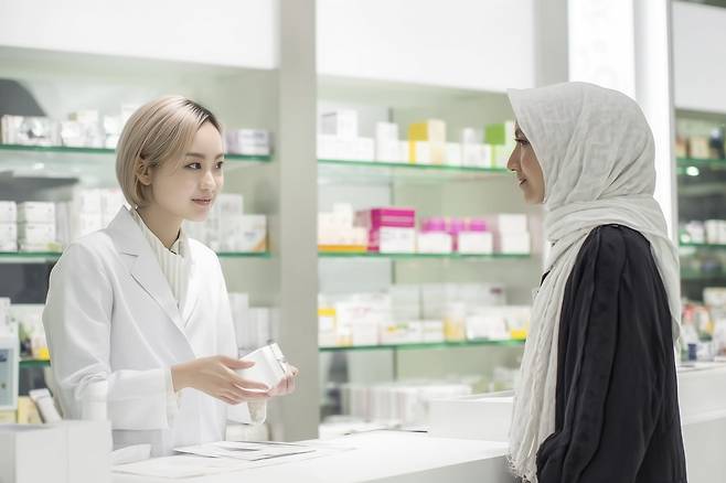 약사에게 약국 뷰티 제품에 대한 설명을 듣는 외국인 관광객의 모습 / 사진=클립아트코리아 제공