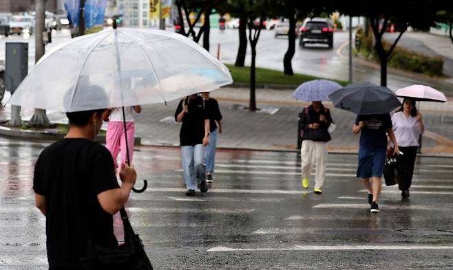 비가 내리는 17일 대구 동구 동대구역네거리 인근에서 우산을 쓴 한 시민들이 이동하고 있다./사진=뉴시스.