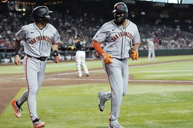 이정후(왼쪽)가 18일 애리조나와 원정경기에서 연장 11회초 대주자로 나서 득점한 뒤 헤라르 엔카나시온과 웃으며 대화하고 있다. 이날 샌프란시스코는 5-1의 승리를 거뒀다. 피닉스(미 애리조나주)ㅣAP뉴시스