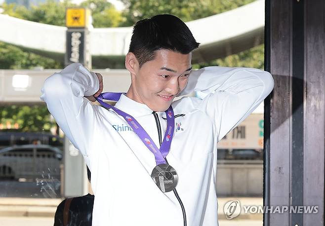 세계육상선수권 은메달 목에 거는 우상혁 (서울=연합뉴스) 김인철 기자 = 2025 도쿄 세계육상선수권대회 남자 높이뛰기 결선에서 은메달을 획득한 우상혁이 18일 서울 강서구 김포국제공항으로 귀국한 뒤 인터뷰에 앞서 은메달을 목에 걸고 있다. 2025.9.18 yatoya@yna.co.kr