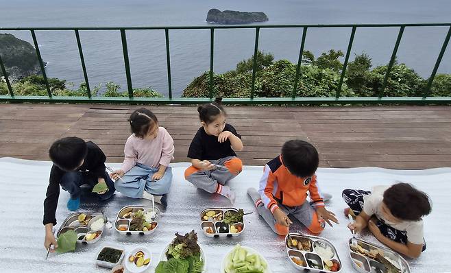 울릉도에서 독도가 가장 잘 조망되는 고 이덕영 선장 기념비 주변에서 식사를 하는 유치원생들. 멀리 죽도가 보인다./저동초등학교 제공