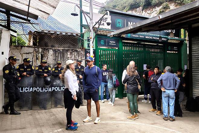 2025년 9월 16일 페루 마추픽추 기차역에서 경찰관들이 관광객 그룹 옆에서 경비를 서고 있다. /연합뉴스