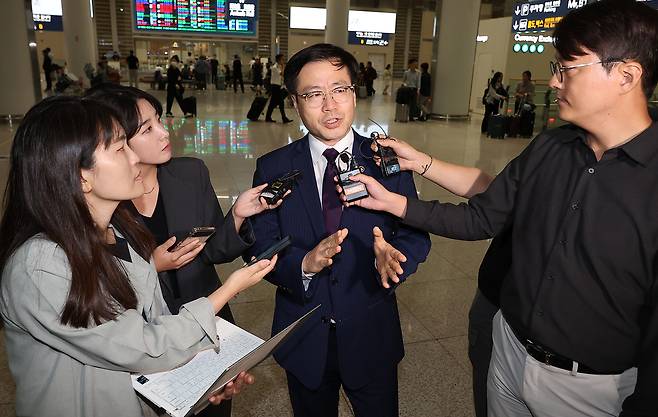 여한구 산업통상자원부 통상교섭본부장이 19일 오전 인천국제공항 제2여객터미널을 통해 귀국하며 취재진 질문에 답하고 있다. [연합]
