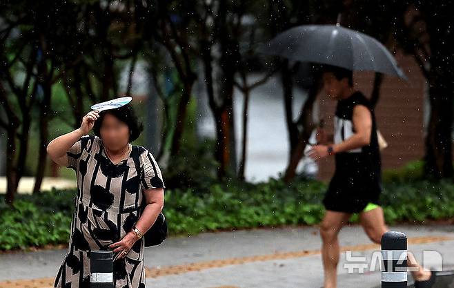 [대구=뉴시스] 이무열 기자 = 비가 내리는 17일 대구 동구 동대구역네거리 인근에서 우산을 준비하지 못한 한 시민이 부채로 머리를 가린 채 이동하고 있다. 2025.09.17. lmy@newsis.com