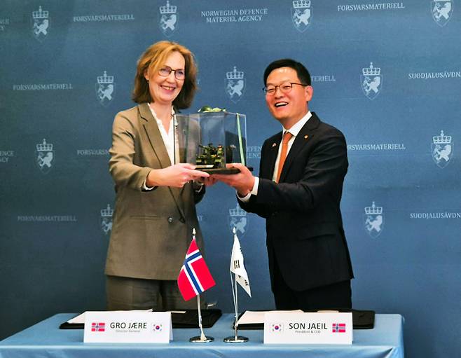 노르웨이 국방물자청에서 18일(현지시간) 열린 노르웨이 K9 계약식에서 손재일 한화에어로스페이스 대표이사(오른쪽)와 그로 예레 노르웨이 NDMA 청장이 기념품을 교환하고 있다. 한화에어로스페이스 제공