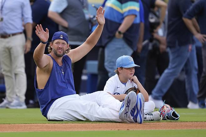 LA 다저스 커쇼가 19일 은퇴를 발표한 뒤 그라운드에서 아들과 함께 편히 앉아 있다. AP연합뉴스