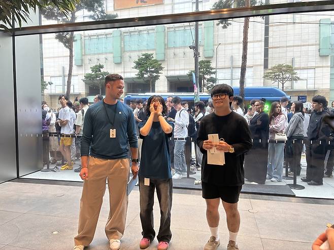 아이폰17 시리즈 사전 예약 1호 수령자 (서울=연합뉴스) 오지은 기자 = 아이폰17 시리즈 사전 예약 1호 수령자 김지민씨가 축하 세레모니를 받고 있다. 2025.9.19