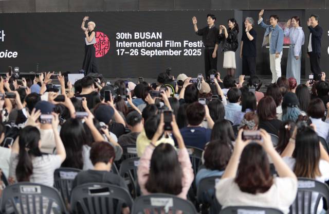 제30회 부산국제영화제 개막 이틀째인 지난 18일 오후 영화의전당 야외무대에서 '어쩔수가없다' 오픈토크가 열렸다. 박찬욱 감독과 배우들이 손을 흔들자 관객들이 일제히 스마트폰을 높이 들어 촬영하고 있다. 이지원 인턴기자