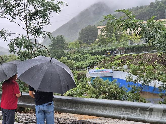 강원 강릉에 단비가 내린 20일 오후 강릉 성산면 오봉리 한국수력원자력 강릉수력발전소에서 예정된 도암댐 도수관로 저류수 방류를 보기 위한 주민과 시 관계자들이 우산을 쓰고 현장을 바라보고 있다. 2025.9.20/뉴스1 ⓒ News1 윤왕근 기자