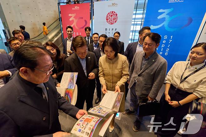 이재명 대통령과 김혜경 여사가 20일 부산 해운대구 영화의 전당에서 부산국제영화제 공식상영작 '극장의 시간들' 관람에 앞서 기념우표 설명을 듣고 있다. (대통령실 제공. 재판매 및 DB 금지) 2025.9.20/뉴스1 ⓒ News1 허경 기자