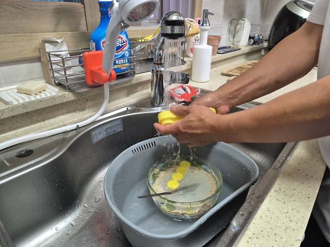 강릉지역 저수조 용량 100톤 이상 아파트 113곳에 대한 시간제 제한급수가 풀린 19일 저녁 강릉 회산동의 한 아파트 주민이 수돗물을 이용해 설거지를 하고 있다. 뉴스1