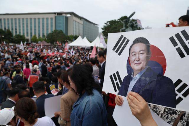 12일 오후 서울 여의도 국회에서 열린 '야당탄압 독재정치 규탄대회'에서 한 참가자가 윤석열 전 대통령 얼굴이 그려진 손피켓을 들고 있다. 전문가들은 진정한 내란 청산을 위해서는 이 같은 일부 윤 전 대통령 지지자들에게 판결에 불복할 빌미를 줘선 안된다고 지적한다. 뉴시스