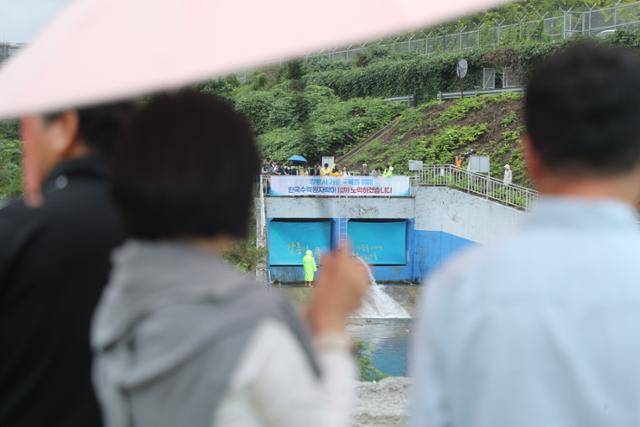 20일 강원 강릉시 성산면 남대천 상류의 강릉수력발전소 방류구 주변에 모인 시민들이 해갈을 위해 2001년 이후 24년 만에 이뤄지는 도암댐 도수관로 비상 방류를 지켜보고 있다. 강릉=연합뉴스