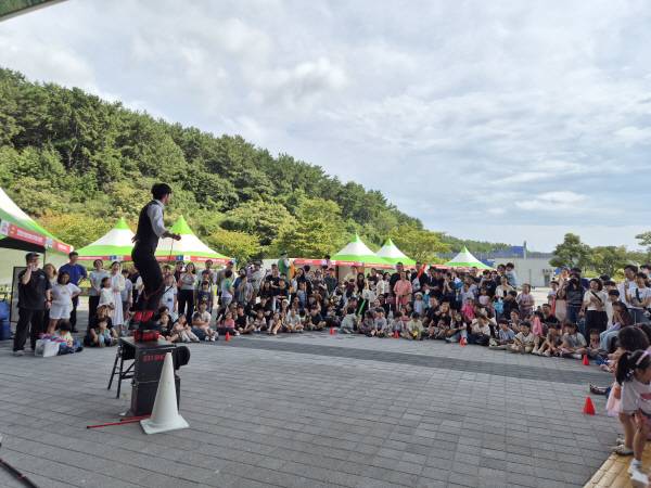 헬로메이커2025 첫날 행사가 열린 20일 오후 국립부산과학관 야외광장에서 체험 참가자들이 코미디 서커스 퍼포먼스를 관람하고 있다. 부산과학기술협의회 제공