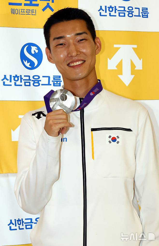 [서울=뉴시스] 박주성 기자 = 2025 도쿄 세계육상선수권대회 남자 높이뛰기에서 은메달을 획득한 우상혁 선수가 지난 18일 서울 강서구 김포국제공항 입국장으로 귀국해 취재진에게 은메달을 들어보이고 있다. 2025.09.18. park7691@newsis.com