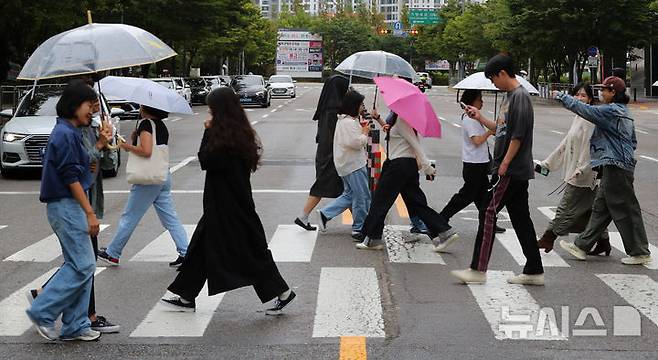 [서울=뉴시스] 김혜진 기자 = 비가 내리는 지난 19일 오후 서울 마포구 상암동 인근에서 우산을 쓴 시민들이 이동하고 있다. 2025.09.19. jini@newsis.com